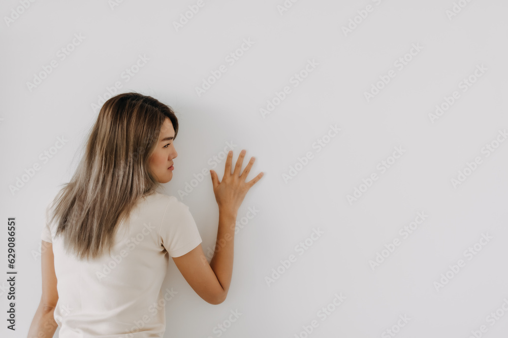 Funny asian woman lie on background try to spy and listen over the wall. Funny asian woman lie on background try to spy and listen over the wall.