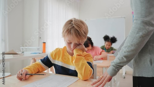 Young primary student stress while examination and feeling worried about having problems learn in classroom at elementary school.Learn and education concept.