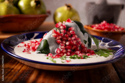 Chiles en Nogada, Typical dish from Mexico. Prepared with poblano chili stuffed with meat and fruits and covered with a walnut sauce. Named as the quintessential Mexican dish for national holidays. photo