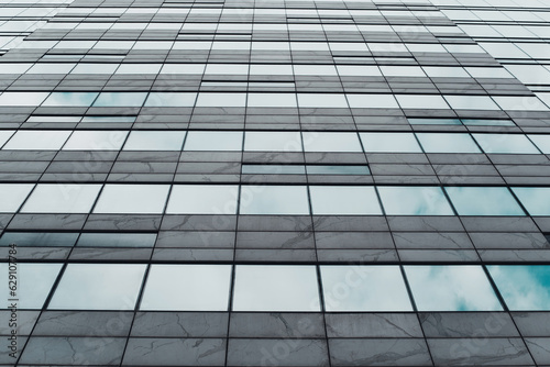 Wall of a tall building  blue windows and tiles. Appearance  low angle view