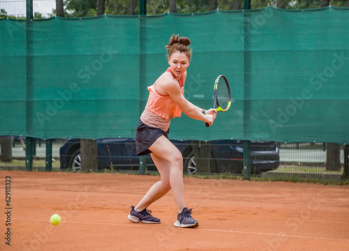 A young woman playing tennis hits backhand. Open ground. © Дворецкая Таня