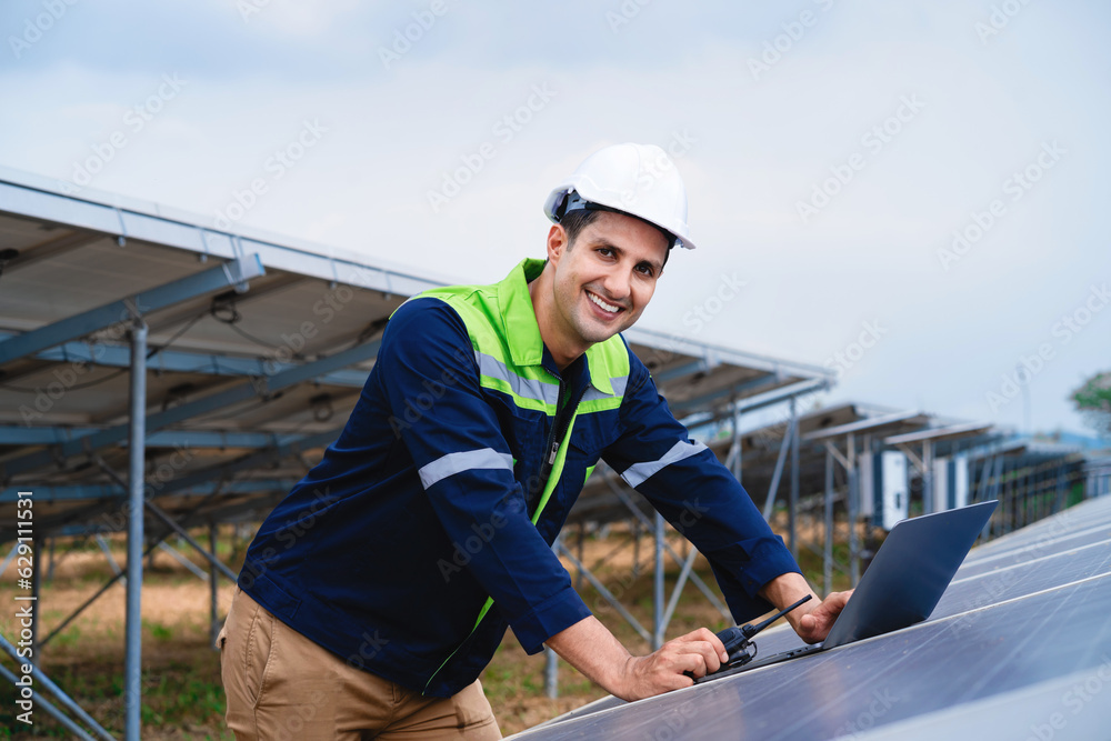 Engineer repairing solar panels Male worker looking at camera and smiling while maintaining solar photovoltaic panel system. The concept of alternative energy. Engineer repairing solar panels Male worker looking at camera and smiling while maintaining solar photovoltaic panel system. The concept of alternative energy.