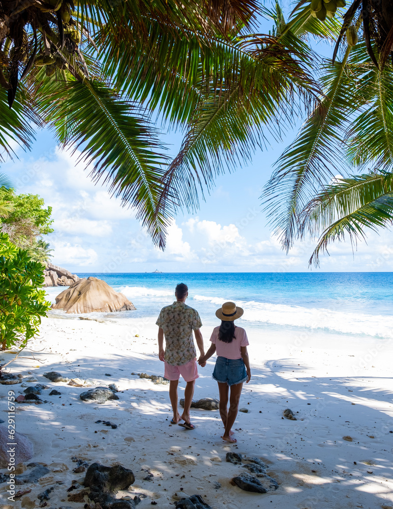 Anse Lazio Praslin Seychelles is a young couple of men and women on a tropical beach during a luxury vacation there. Tropical beach Anse Lazio Praslin Seychelles Islands Anse Lazio Praslin Seychelles is a young couple of men and women on a tropical beach during a luxury vacation there. Tropical beach Anse Lazio Praslin Seychelles Islands