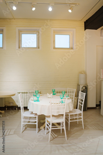 A table in a white room served with dishes for a holiday.  © andrey