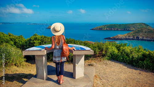 Woman tourist enjoying panoramic view of breton coast and island- Brittany in France