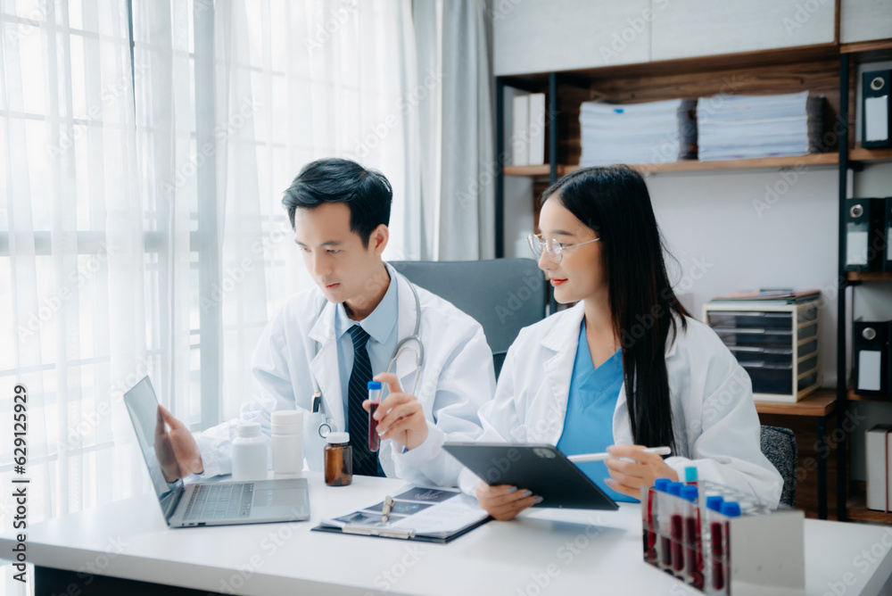 Portrait of Asian doctor speaking to colleagues during medical meeting in conference room or Medical Laboratory Portrait of Asian doctor speaking to colleagues during medical meeting in conference room or Medical Laboratory