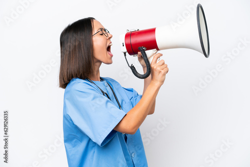 Young surgeon doctor woman isolated on white background shouting through a megaphone