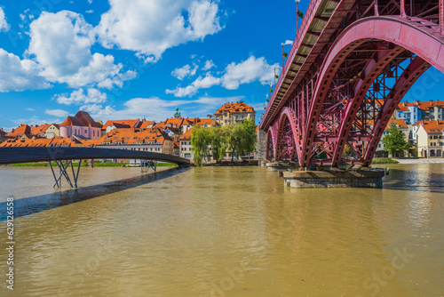 New wooden bridge and main bridge over Drava river and cityscape of city of Maribor, Slovenia 