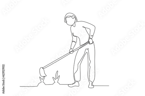 Continuous one line drawing a woman is hoeing the grass
