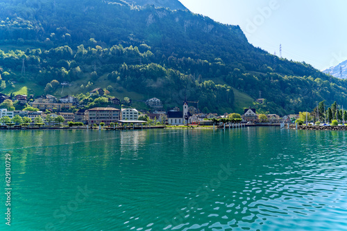 Scenic view of Swiss village of Flüelen with beautiful reflections in water on a sunny spring morning. Photo taken May 22nd, 2023, Flüelen, Canton Uri, Switzerland.