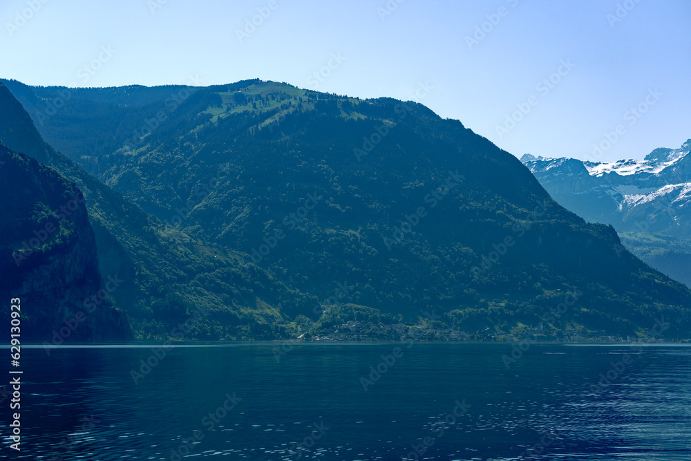 Scenic view of mountain panorama with Lake Lucerne in the foreground on a sunny spring day. Photo taken May 22nd, 2023, Canton Uri, Switzerland.