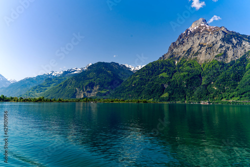 Scenic mountain panorama with Lake Lucerne in the foreground and Swiss village Fl  elen in the background on a sunny spring day. Photo taken May 22nd  2023  Lake Lucerne  Switzerland.