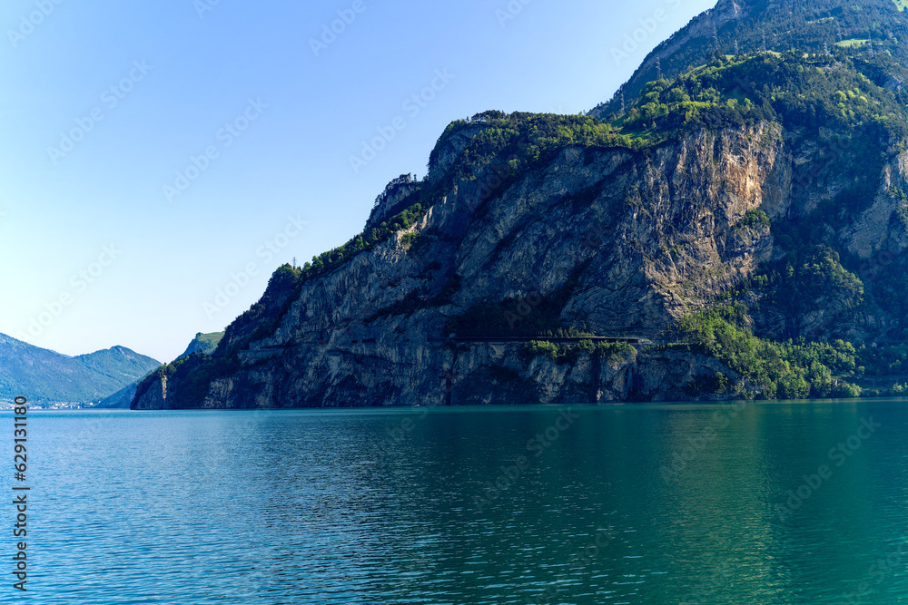 Scenic landscape in the Swiss Alps with Lake Lucerne in the foreground and mountain panorama in the background on a sunny spring day. Photo taken May 22nd, 2023, Lake Uri, Switzerland.