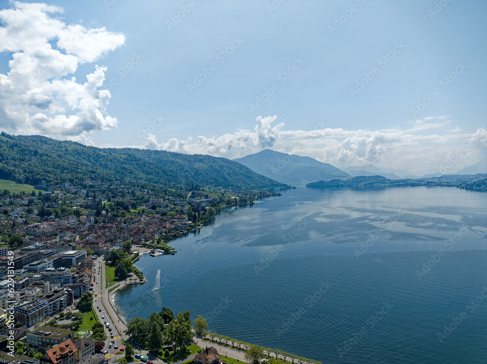 Aerial view of Swiss City of Zug with Lake Zug and lakeshore and mount Rigi and mount Pilatus in the background on a sunny spring day. Photo taken May 22nd, Zug, Switzerland.