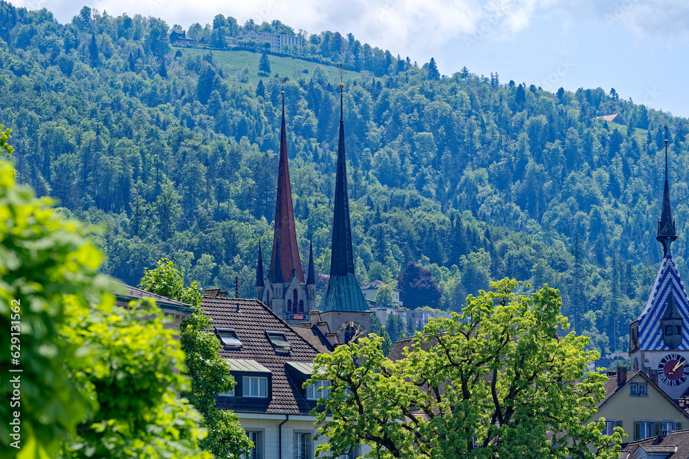 Scenic view of rooftops at the old town of Swiss City of Zug with spire of clock tower and church tower on a sunny spring noon. Photo taken May 22nd, 2023, Zug, Switzerland.