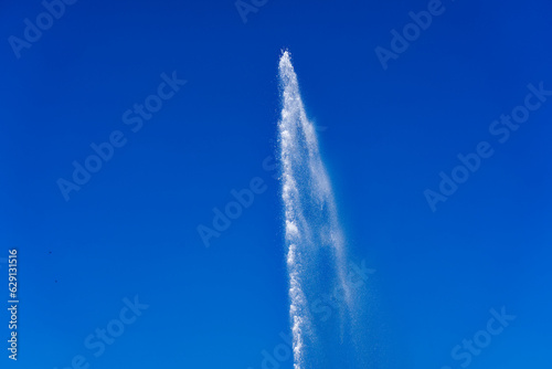 Scenic view splashing water fountain against blue background at Swiss City of Zug on a sunny sprig day. Photo taken May 22nd, 2023, Zug, Switzerland.