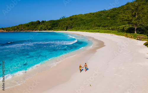 Anse Cocos La Digue Seychelles, couple of men and women on a tropical beach during a luxury vacation in Seychelles. Tropical beach Anse Cocos La Digue Seychelles.  photo