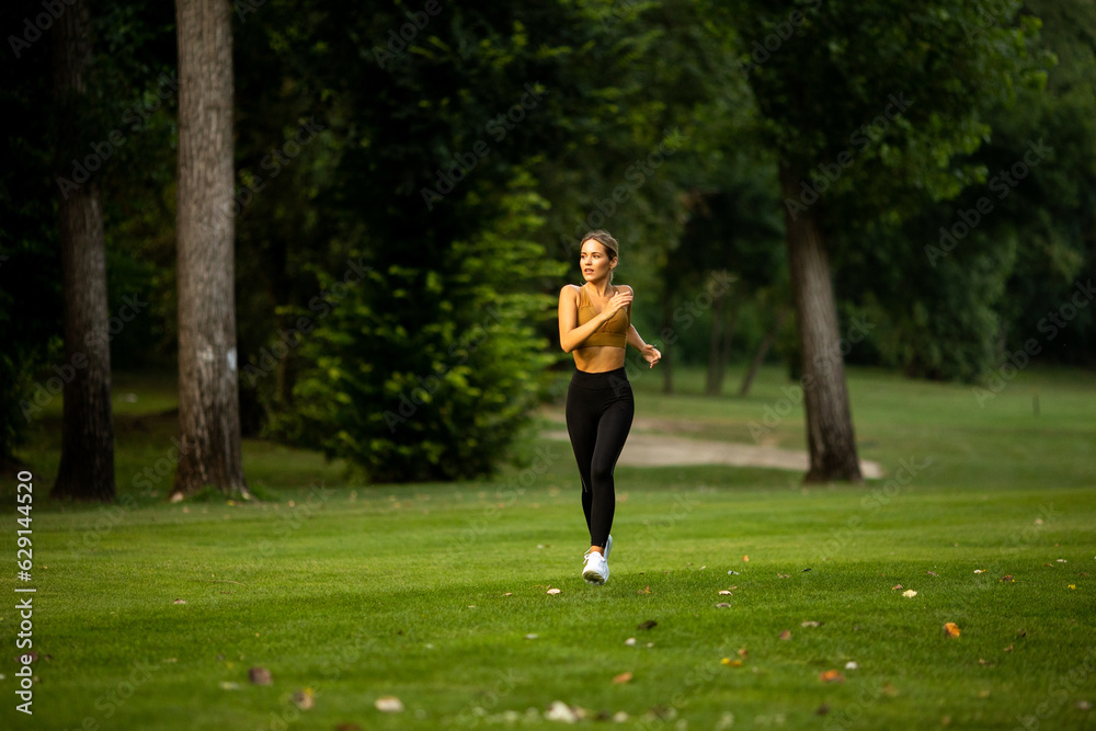 Pretty young woman running in the park