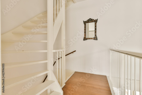 a white staircase with wood flooring and wooden handrails in an empty living room on a sunny day