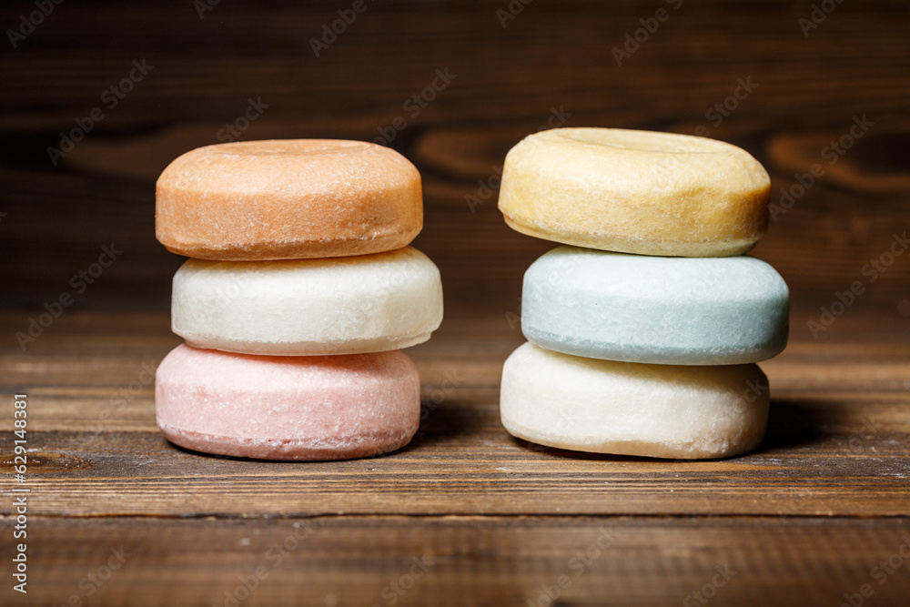 Colorful bars of round dry shampoo on a wooden background. Colorful bars of round dry shampoo on a wooden background.