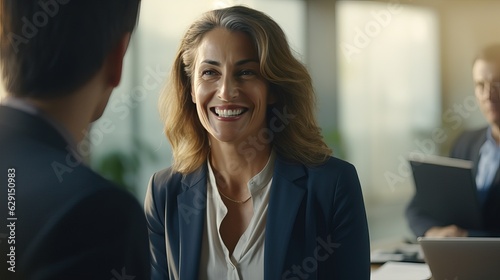 portrait of a businesswoman. smile and relaxing . miidle age of woman and team . office and tower view background.