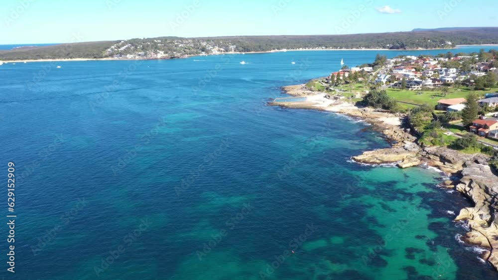 Aerial drone view of Cronulla South along Oak Park Beach and Rock Pool in the Sutherland Shire, South Sydney, NSW Australia looking south over Port Hacking on a sunny day in July 2023  