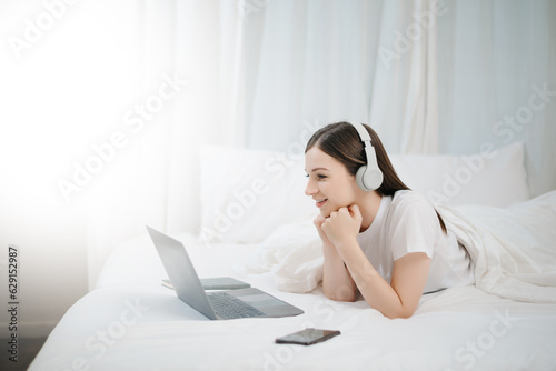 Beautiful woman resting and watching movie in bed at bedroom in morning Lifestyle