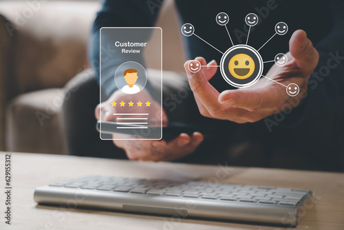 customer service evaluation and feedback rating. costumer review concept, man using phone chooses happy smiling face..