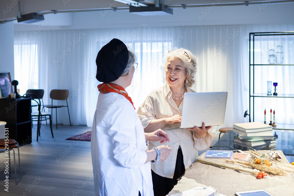 Obraz premium シニア女性の制作チーム会議