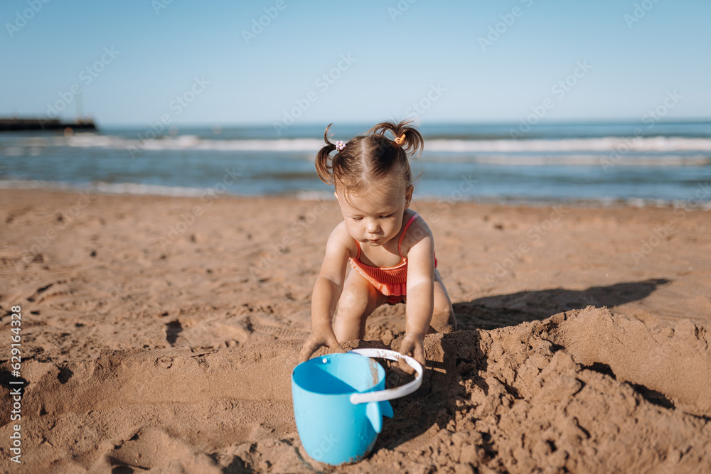 little child sea, girl in swimsuit joyful plays on the beach little child sea, girl in swimsuit joyful plays on the beach