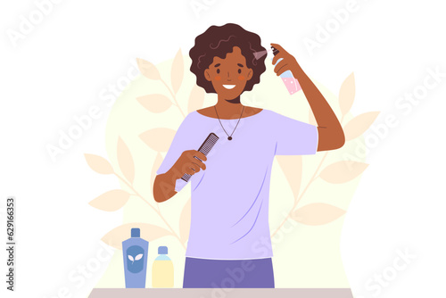 Young african american woman takes care of her hair, applying moisturizing spray to curly hair
