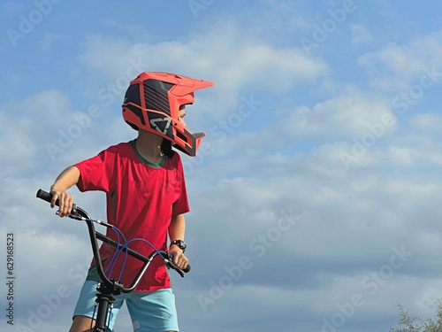 boy in a helmet with a beymix bike on the background blue sky