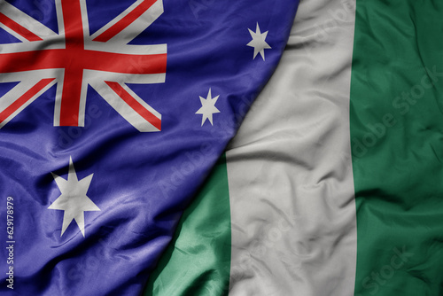 big waving realistic national colorful flag of australia and national flag of nigeria .