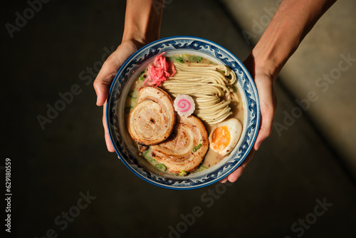 Crop female with bowl of ramen in hands