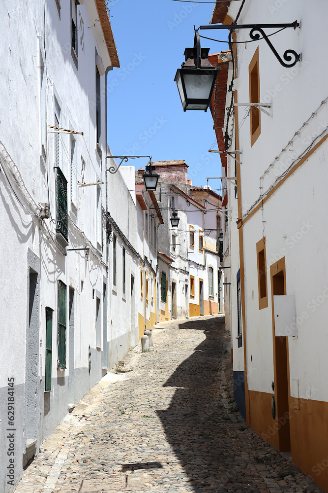 Narrow alley with typical and old white-painted houses in Évora, Alentejo, Portugal