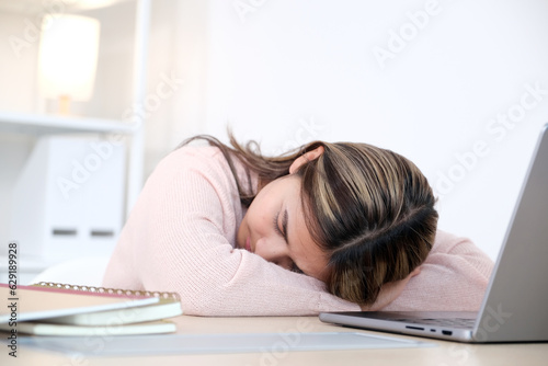 Young asian woman sleeping at her working desk