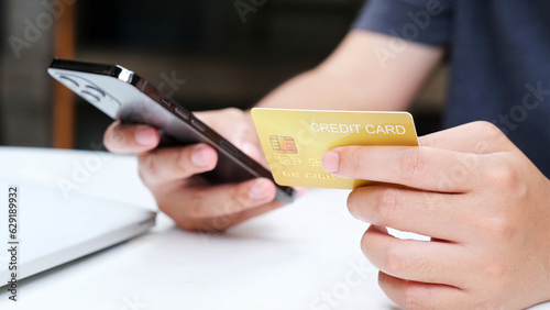 Man hand holding mobile phone and credit card for shopping online