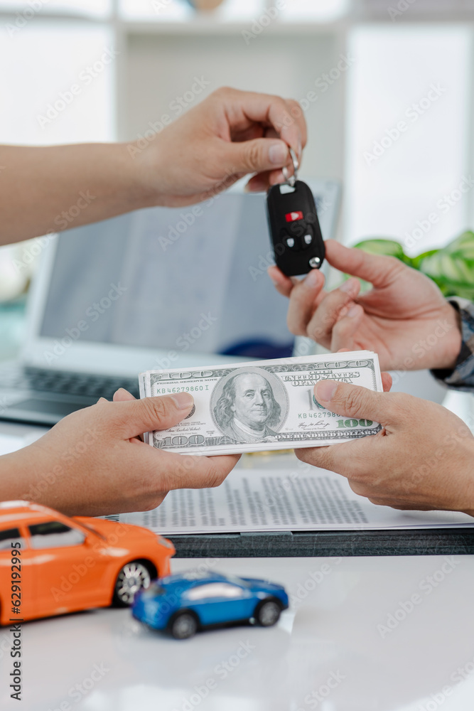 Car dealer calculates interest rates and car loan costs. Providing financial and insurance services While the customer reads the terms and conditions of the contract in the dealer's office. Car dealer calculates interest rates and car loan costs. Providing financial and insurance services While the customer reads the terms and conditions of the contract in the dealer's office.