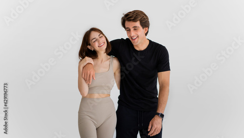 Laughing cheerful young caucasian man hugging woman in sportswear enjoy workout together, have fun