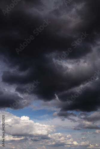 Storm rainy dramatic sky with dark rain grey cumulus clouds and blue sky background texture, thunderstorm, heaven