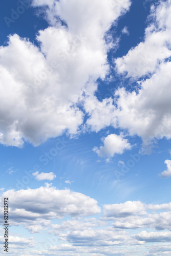 Blue cloudy sky with many beautiful white clouds in sunlight background texture