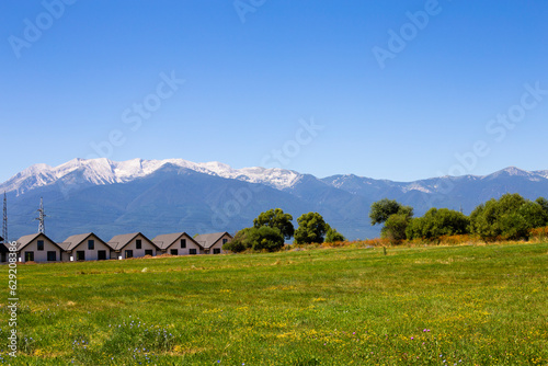Panoramic view of houses against the backdrop of mountains and a meadow with wildflowers in Bulgaria