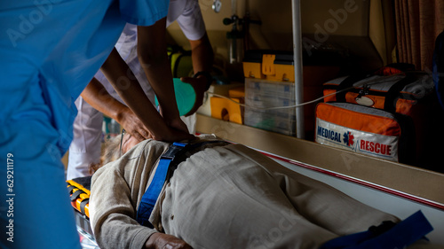 Two rescuers helping a patient to breath properly in am ambulance van. Paramedics work together to let patient get enough oxygen.