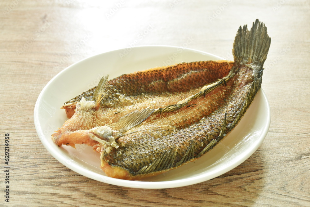 deep fried striped snake head fish with salt on plate