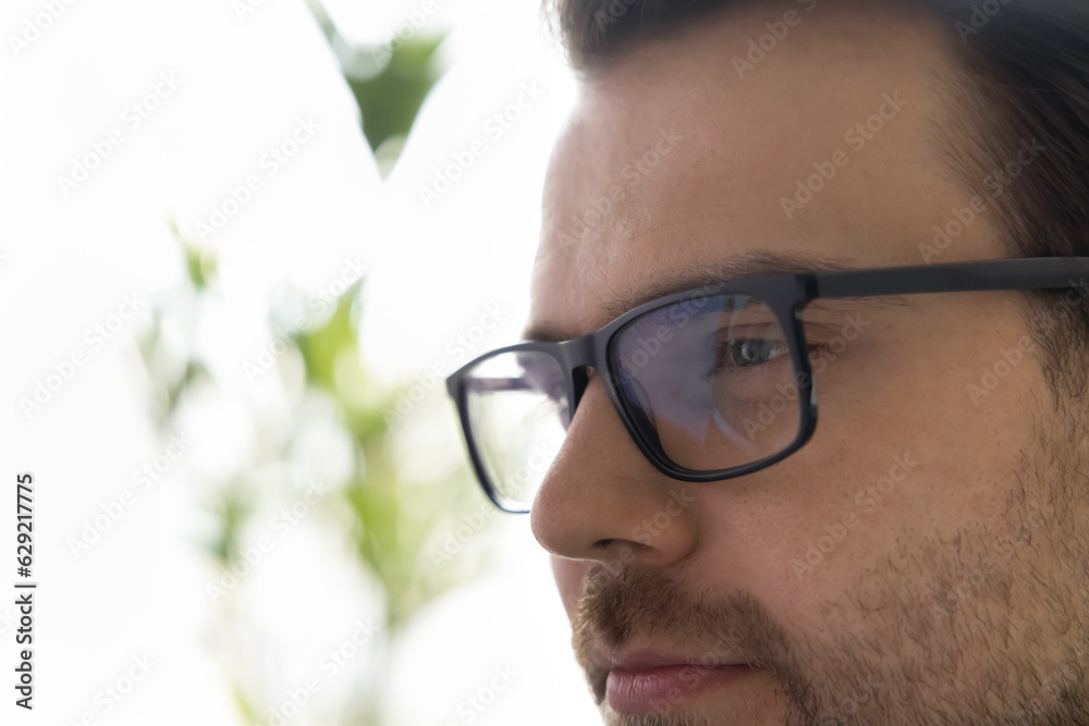 Face of thoughtful dreamy handsome adult man with stubble looking away, wearing stylish trendy glasses with elegant black rim. Eyeglasses optic store customer close up portrait Face of thoughtful dreamy handsome adult man with stubble looking away, wearing stylish trendy glasses with elegant black rim. Eyeglasses optic store customer close up portrait
