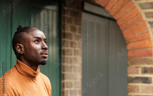 Black male model looking up outdoors.