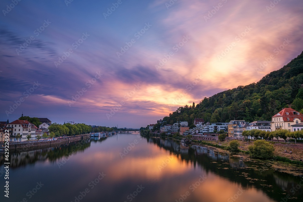 a river is flowing between two mountains and houses in the foreground