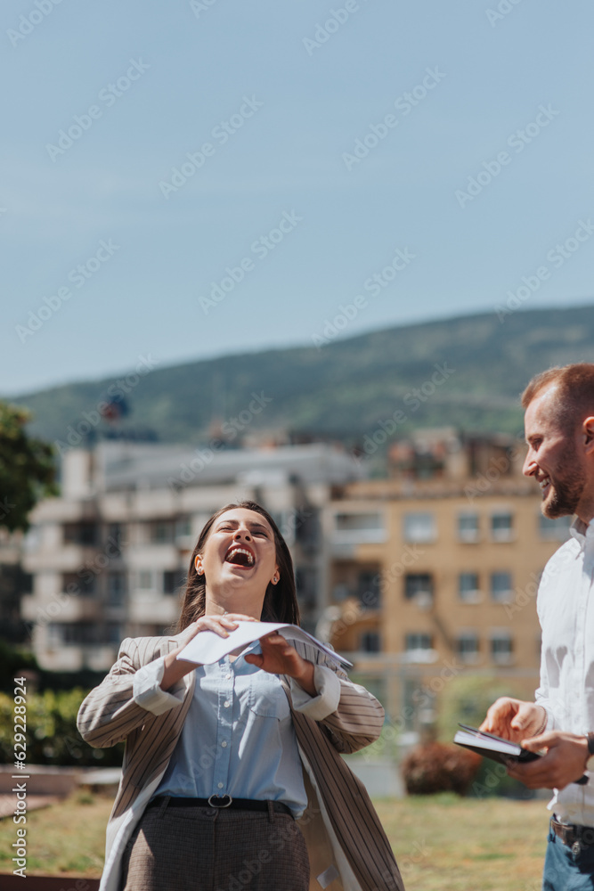 Positive business employees having fun during working hours out in the city. Businesswoman laughing at her male colleague joke