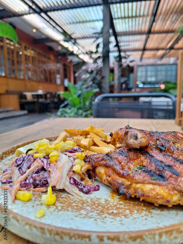 A portion of Peri-Peri Chicken with fries and salad on a plate