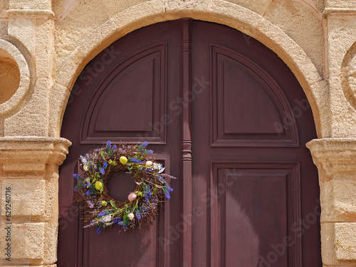 travel to city of Lindos on island of Rhodes, Greece. decoration for Easter, a wreath with flowers and Easter eggs on the door of the house